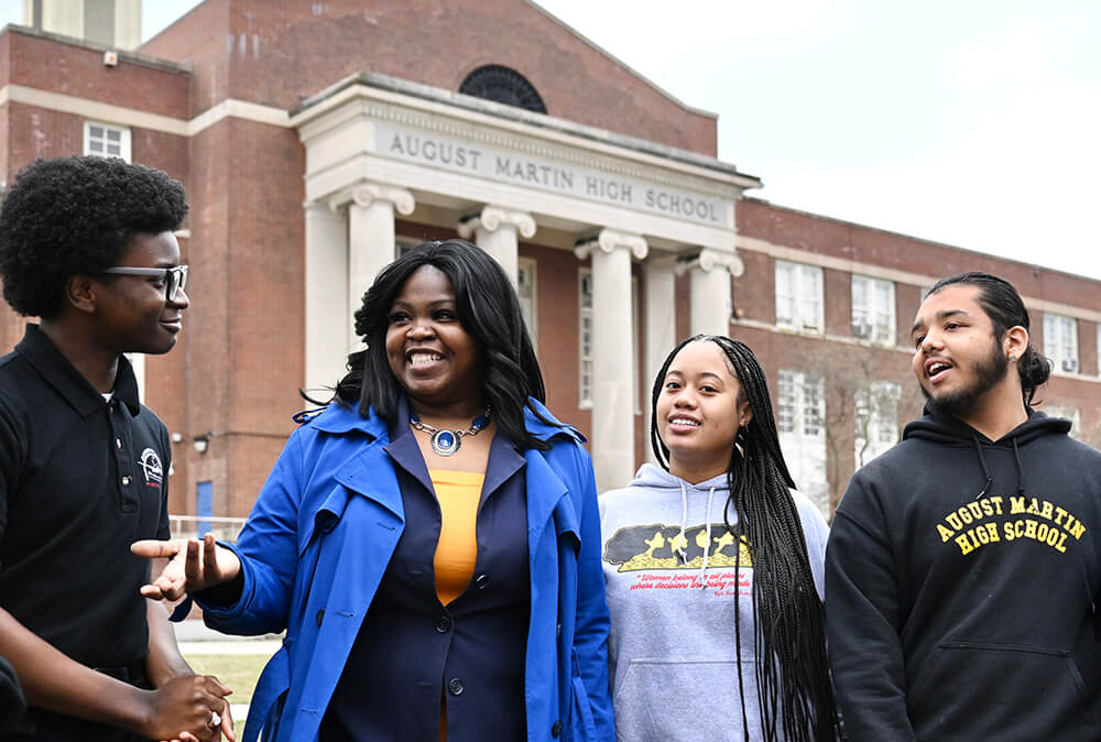 Stephanie Smiley walking and talking with students outside August Martin High School