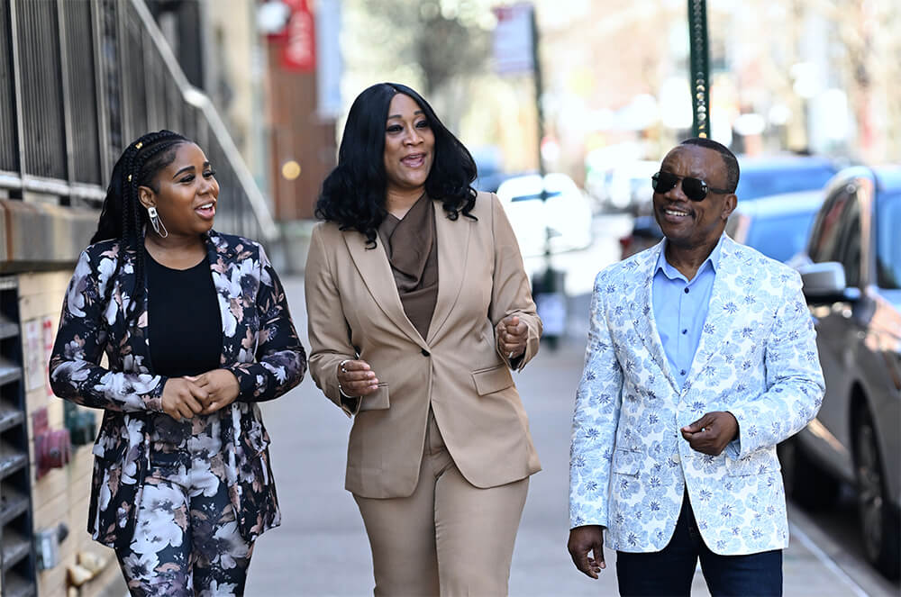 Sophia Shaw, center, walking outside with staff at HeartShare, female staff member on the left and fellow GSSW alum Cosmos Peters on the right