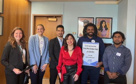 group of students standing in office in state capitol smiling at camera